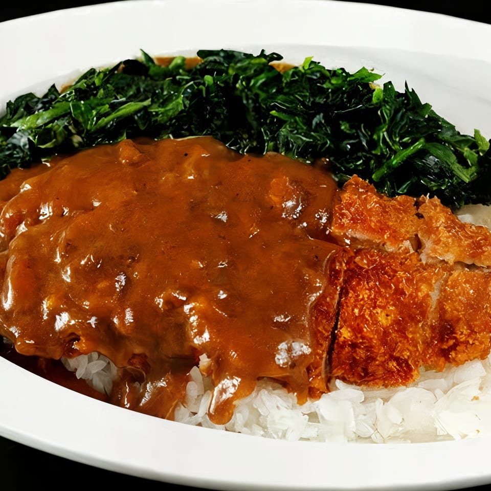 Nippon Curry's Japanese curry with crispy tonkatsu, white rice, and a side of green vegetables.