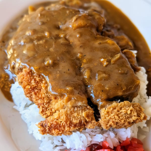 Close-up of Nippon Curry's katsu curry, featuring crispy fried pork cutlet, rich brown curry, and white rice.