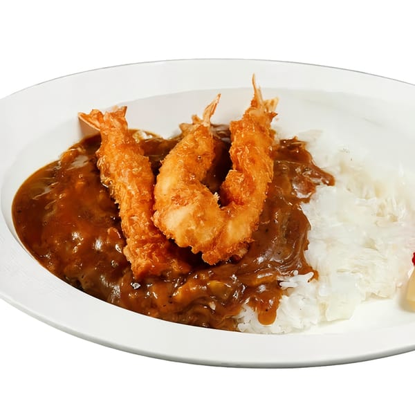 Nippon Curry's Japanese curry with three crispy fried shrimp and white rice on a white plate.