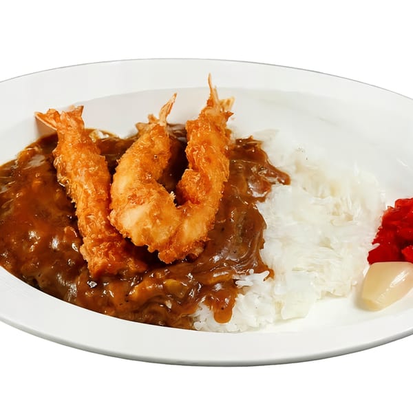 Japanese curry with three crispy fried shrimp, white rice, and pickled ginger on a white plate.